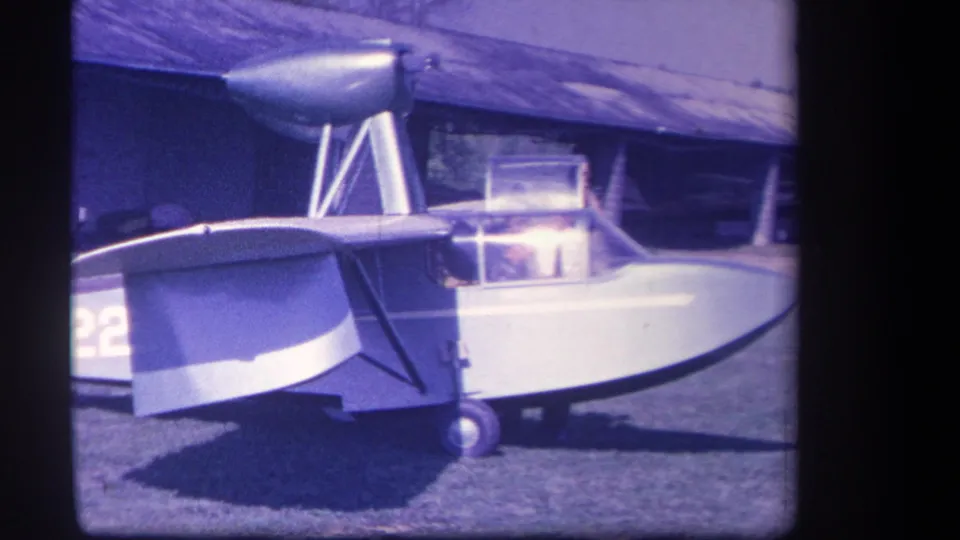 1959 Yucaipa home-movie frame showing the aircraft cockpit area with a bright reflection or raised canopy panel.