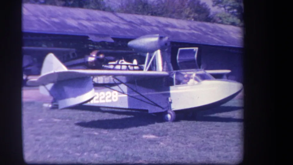 Small amphibious aircraft N2228 appears parked in rural Yucaipa, California, with a person inside the open cockpit.