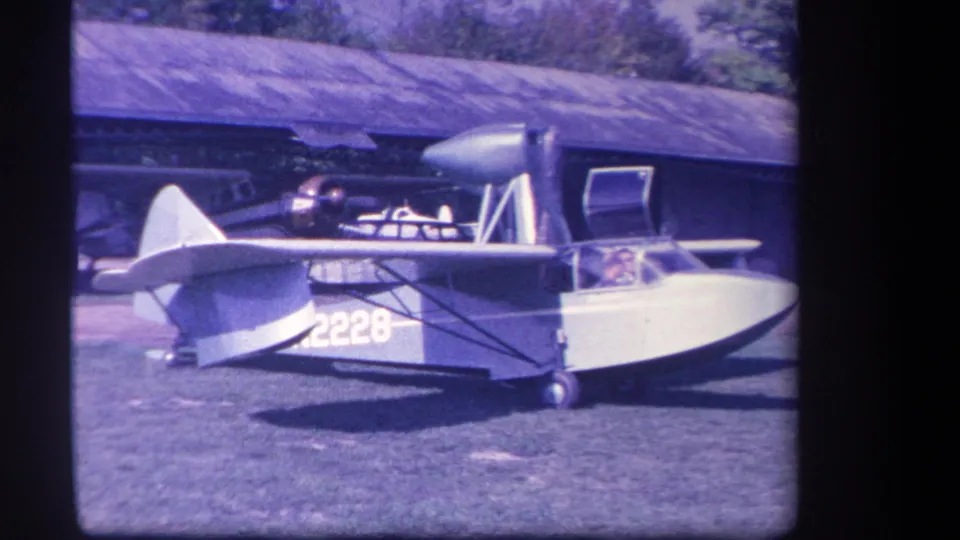 1959 Yucaipa-area home-movie frame of the small amphibious aircraft, showing its struts, cockpit area, and painted number on the fuselage.
