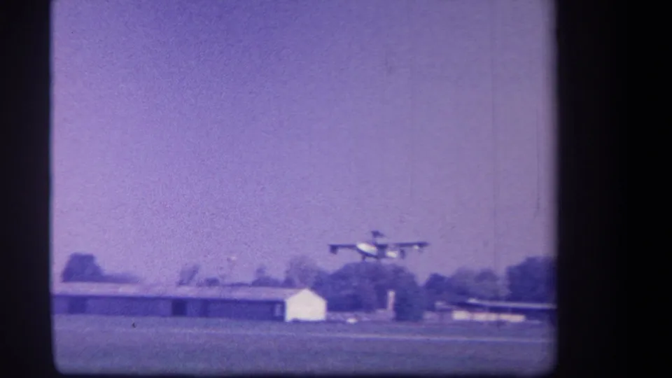 Small propeller aircraft appears near the runway area at a rural Yucaipa, California airfield in this 1959 8mm home-movie frame.