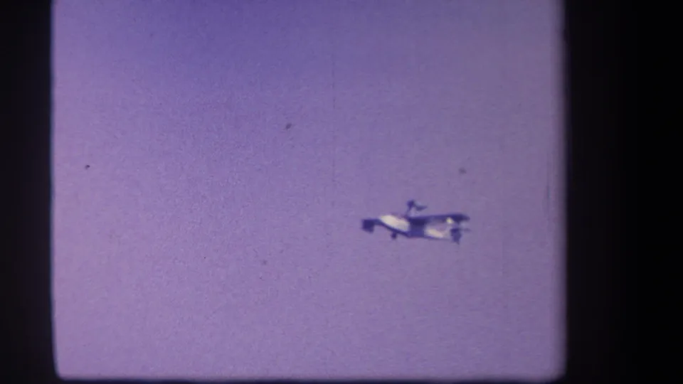 The plane continues climbing across a hazy purple sky, with the ground no longer visible in the sampled frame.