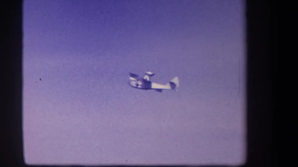 Distant small aircraft remains high in frame against a pale purple sky, supported by the 1959 Yucaipa home-movie metadata.