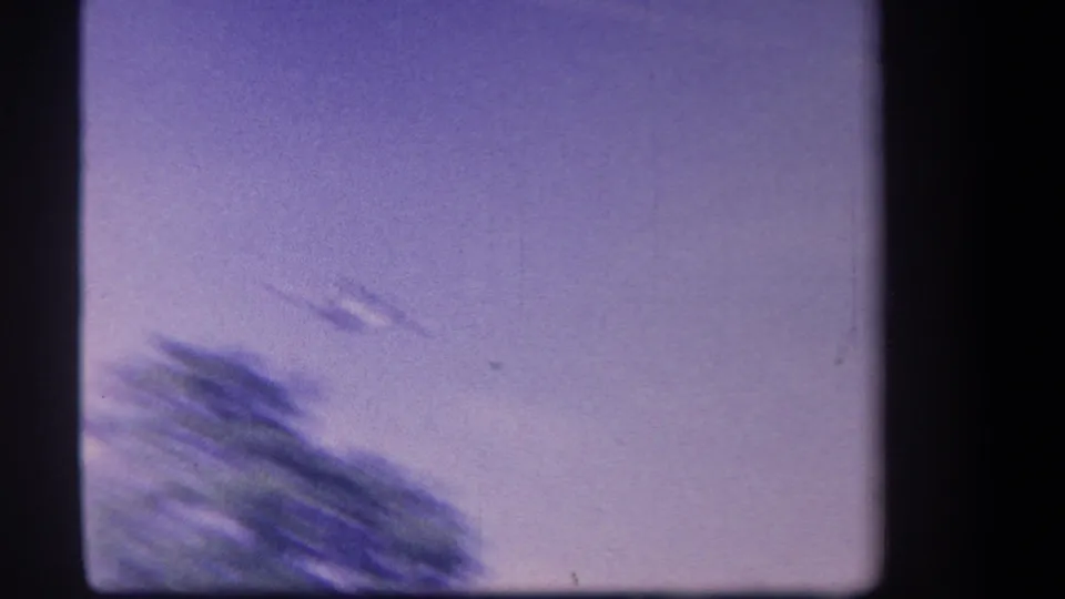 The handheld camera catches blurred trees and open sky while tracking the aircraft in the Yucaipa 1959 aviation clip.