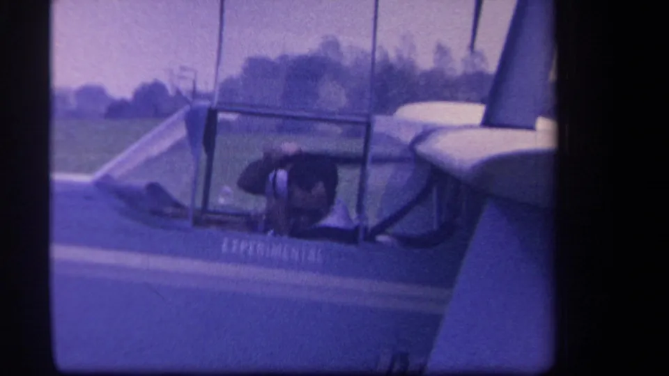 Close 8mm view of the aircraft cockpit area in Yucaipa, with glazing, wing structure, and experimental lettering visible.