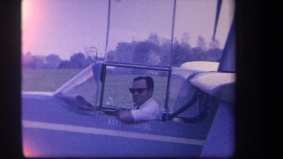 1959 Yucaipa-area home-movie frame showing the seated pilot and partial experimental marking on the aircraft side.