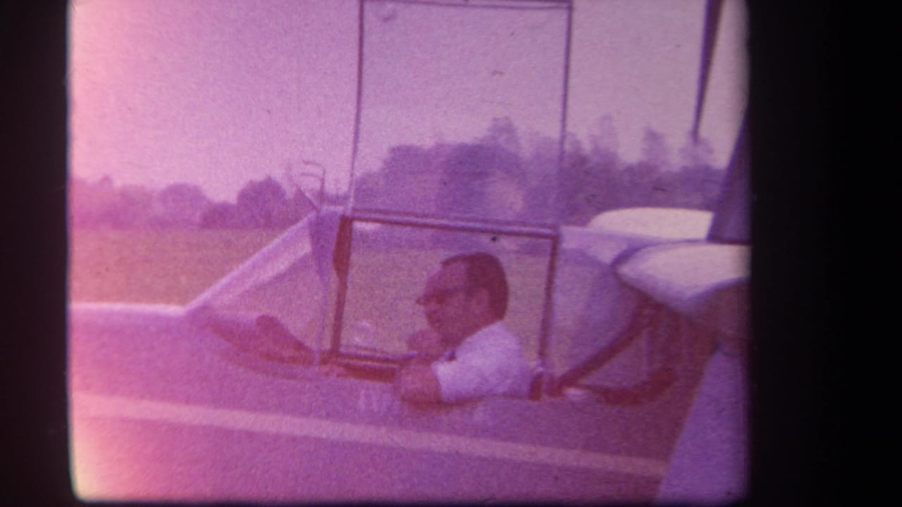 In 1959 Yucaipa-area home-movie footage, a man in a white shirt sits inside the cockpit of a small amphibious aircraft.