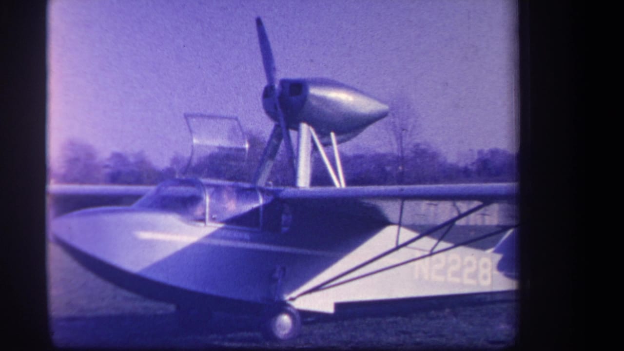 1959 home-movie frame from Yucaipa, California, showing aircraft N2228 with a high wing, canopy, and propeller assembly on grass.