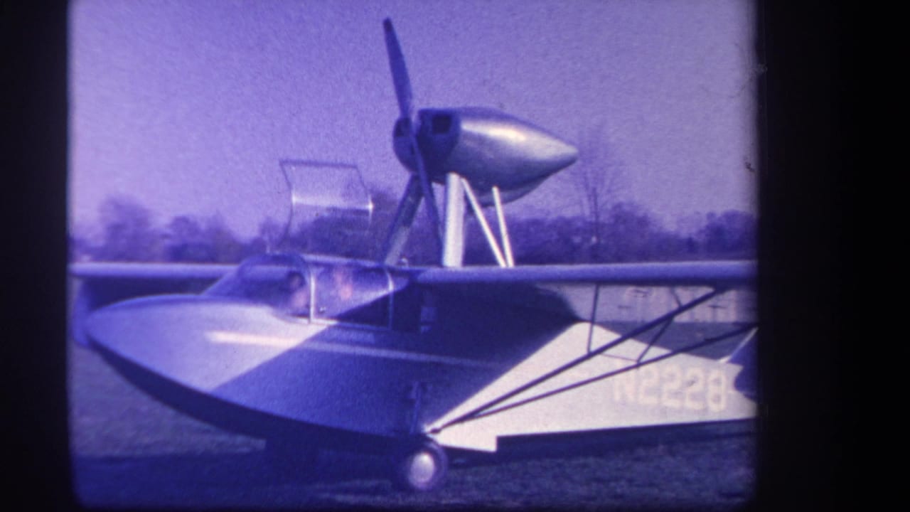 Close view of the aircraft side, wing, canopy, and rear propeller structure.