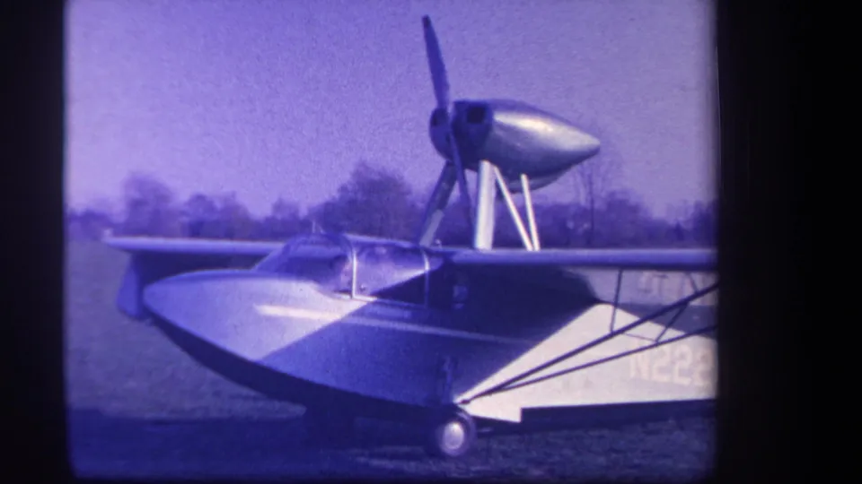 1959 Yucaipa home-movie frame showing the amphibious aircraft from the side as the propeller starts to spin.