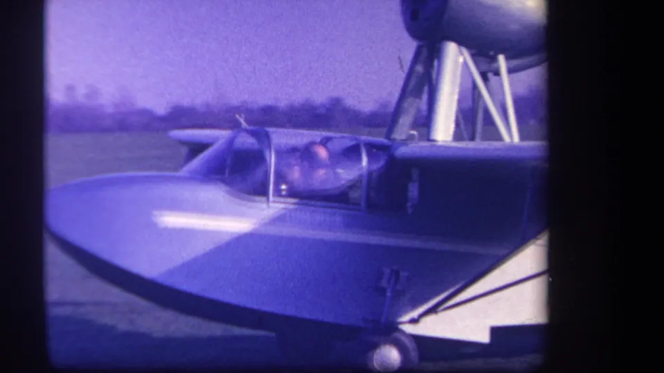 1959 Yucaipa-area frame showing a side view of the cockpit occupant and nearby aircraft tail structure.