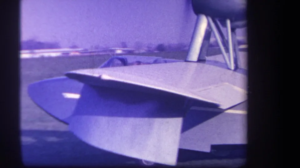 1959 Volmer Yucaipa home-movie frame showing the aircraft wing and tail surfaces with the cockpit partly obscured in the background.