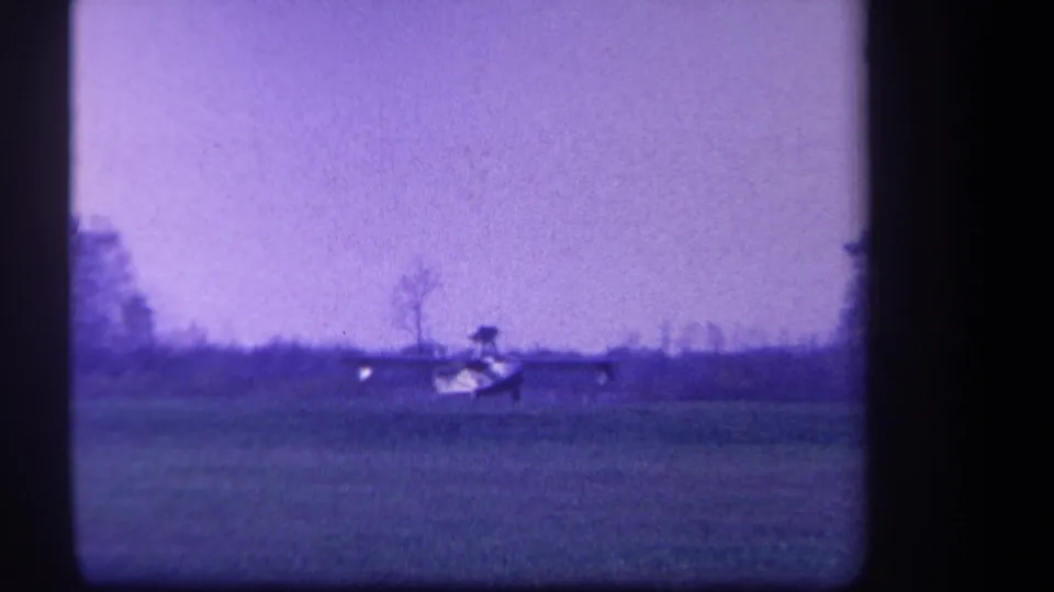 Distant light aircraft remains on the grassy field in the supplied 1959 Yucaipa, California home-movie clip.