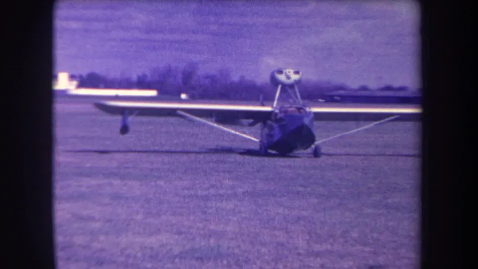 Final 1963 frame of the small high-wing aircraft parked on the grassy Yucaipa-area field.