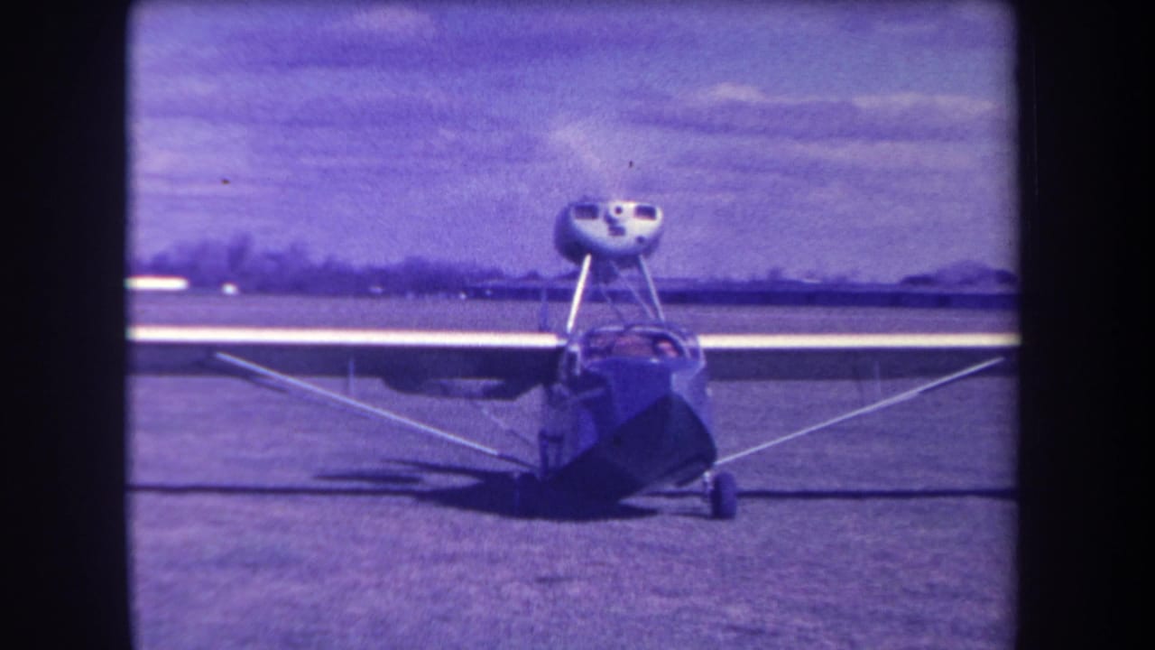 Small amphibious aircraft facing the camera on a grass airfield.