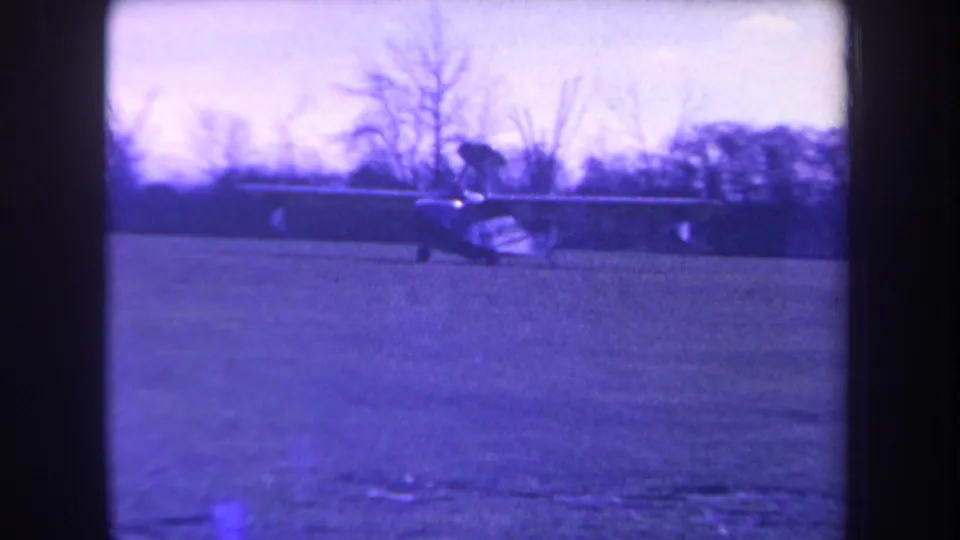 Small amphibious propeller aircraft seen on a grassy field in supported 1963 Yucaipa-area home-movie footage.