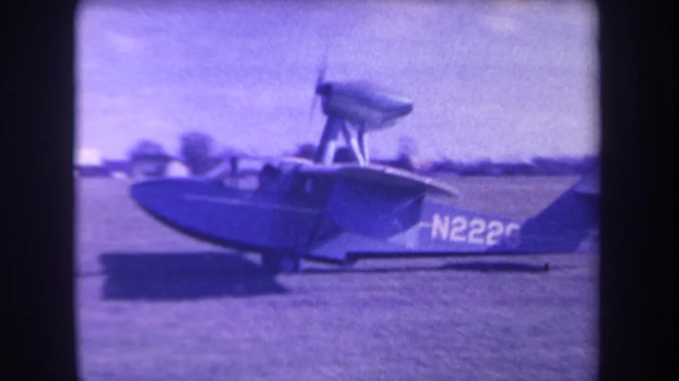 Side view of the amphibious aircraft on a grass field, with a partial N2226 registration visible on the tail area.