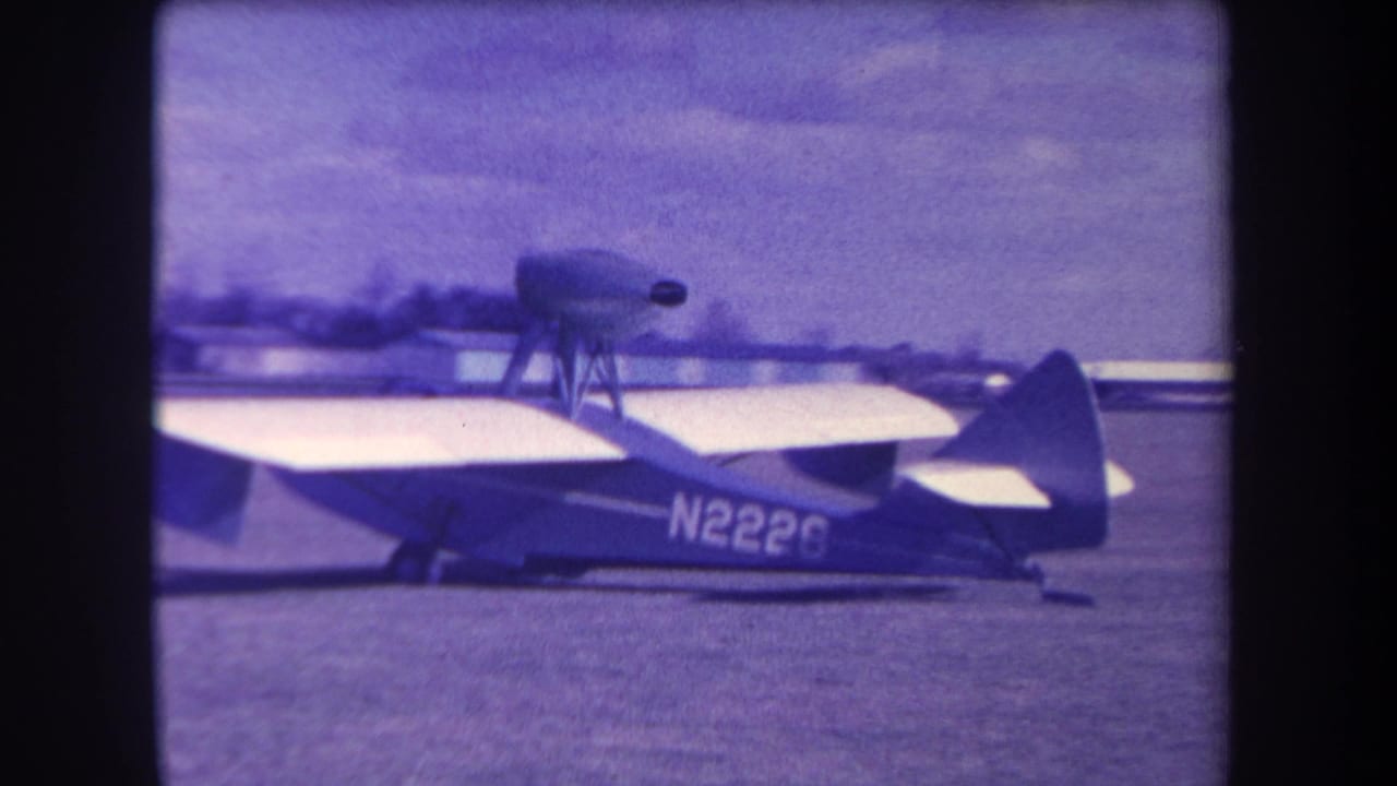 1963 8mm frame from Volmer Yucaipa showing a small aircraft side-on with a top-mounted propeller and registration N2228.