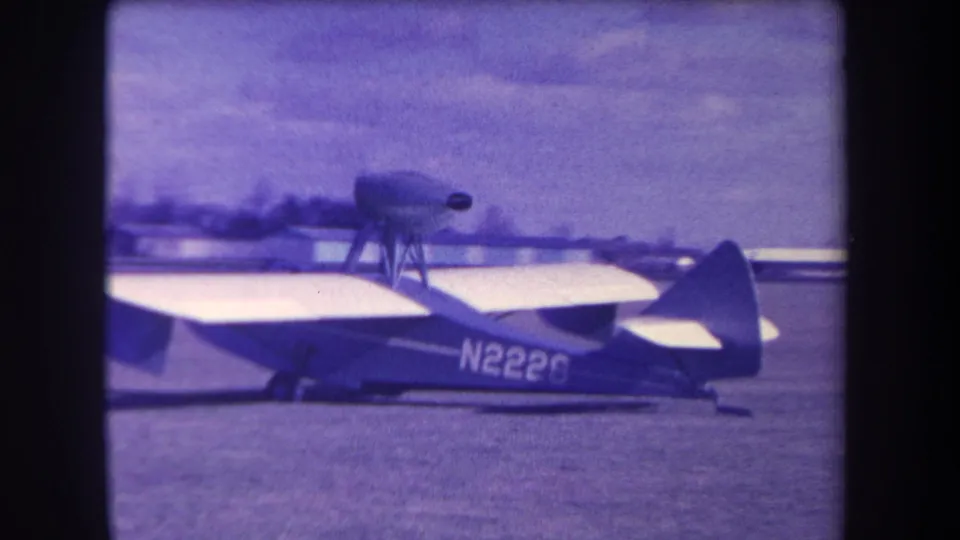 1963 8mm frame from Volmer Yucaipa showing a small aircraft side-on with a top-mounted propeller and registration N2228.
