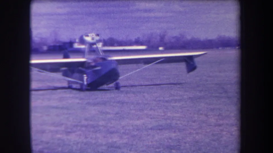 1963 8mm frame showing the Volmer Yucaipa amphibious aircraft nearly head-on at a grassy California airfield.