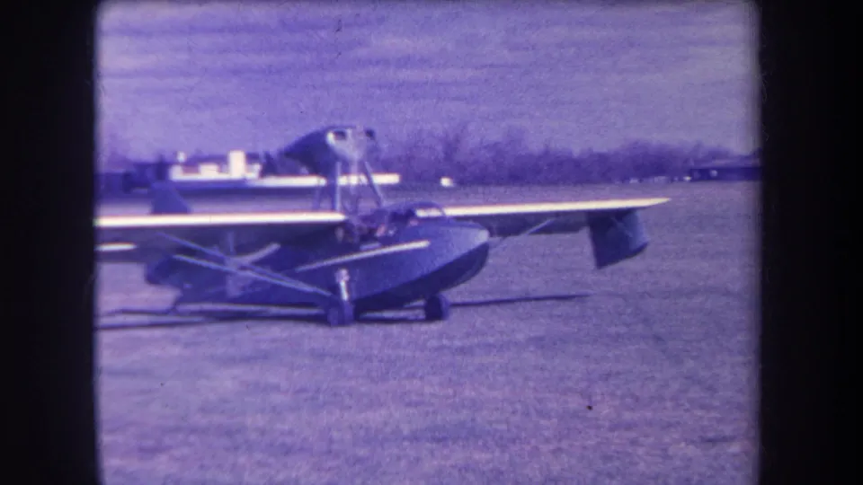 A closer 1963 home-movie view shows the amphibious aircraft on the Yucaipa grass field, with its wing, hull and cockpit area visible.