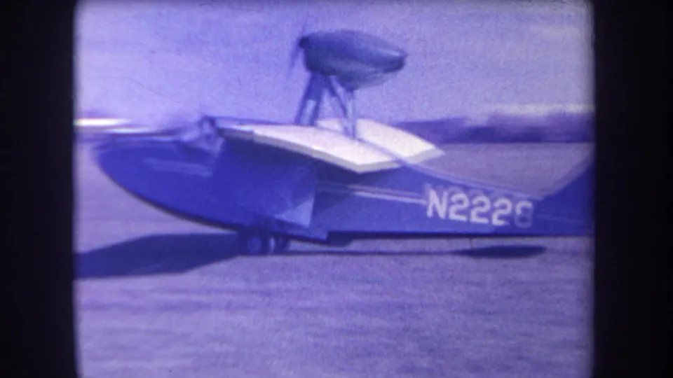 Closer 1963 8mm view of the amphibious aircraft’s white wing, blue hull, landing gear, and N2226 registration at Yucaipa.