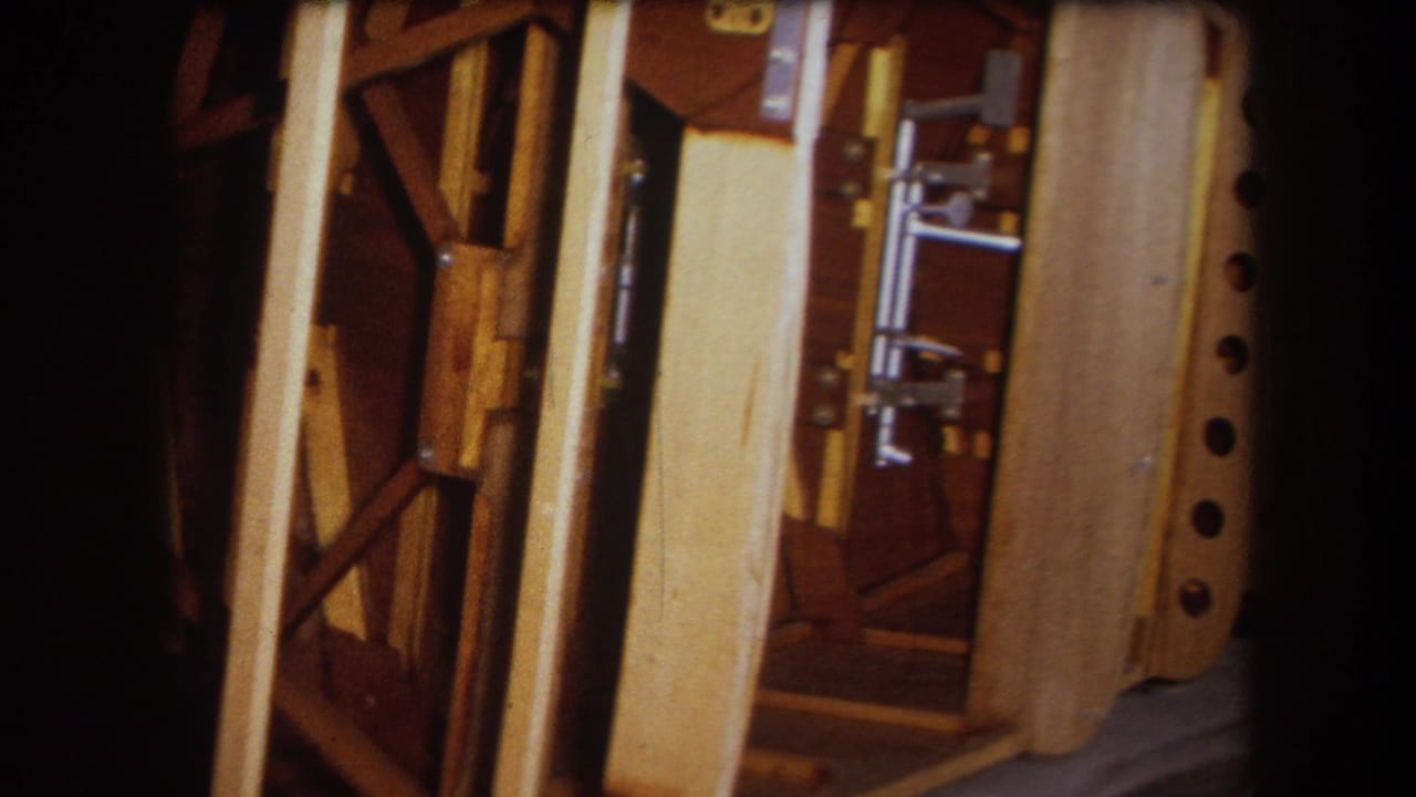 Close view of exposed wooden wall framing with vertical posts and diagonal braces.