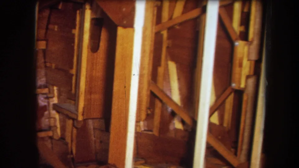 1964 Yucaipa home-movie frame with close wooden framing details, including braces, posts, and unfinished wall structure.