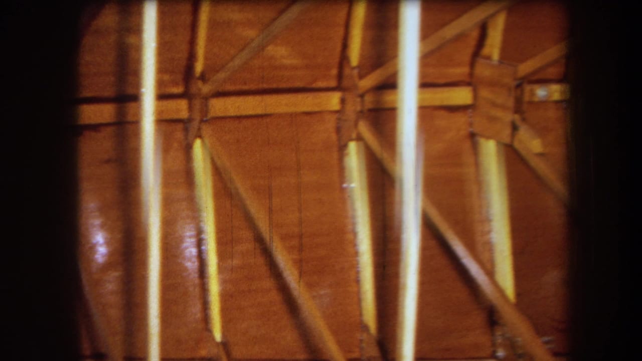Wooden wall framing with diagonal supports and bright vertical film streaks.