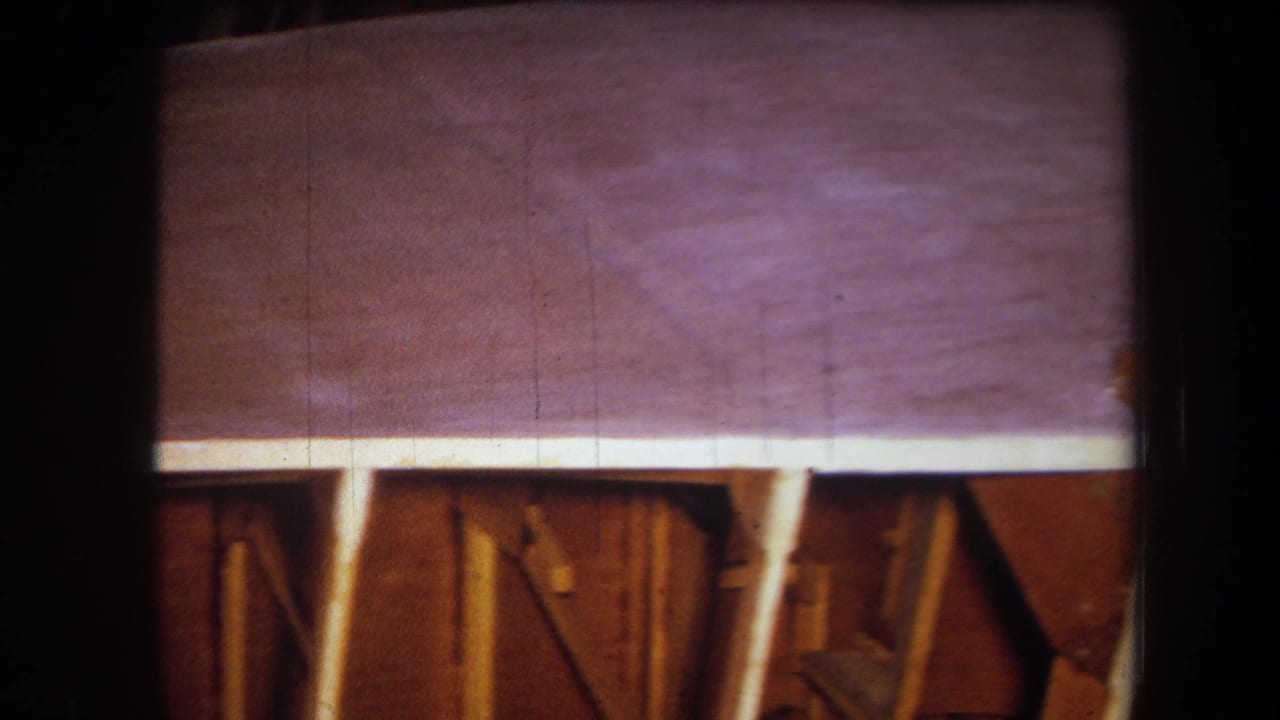Purple-tinted wooden surface above exposed framing and supports.