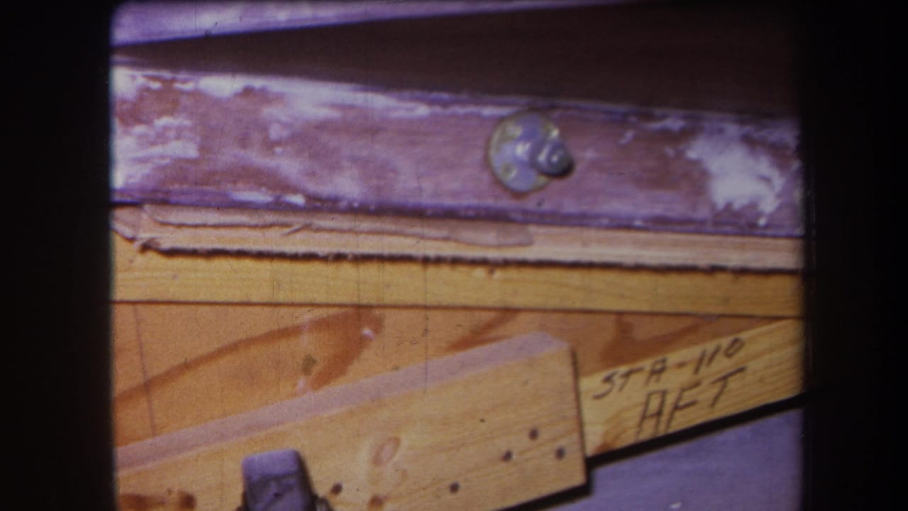 Close 8mm view of wood planks and a weathered purple metal member with visible bolt hardware and STA-110 AFT marking in Yucaipa metadata context.