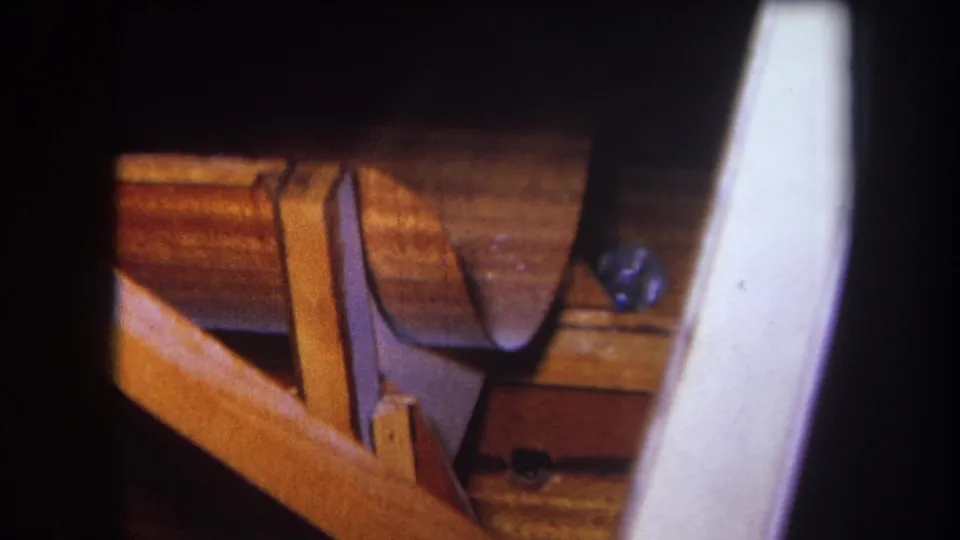 1964 Yucaipa woodshop detail with curved wood, joinery-like supports, warm bench surfaces, and soft 8mm grain.