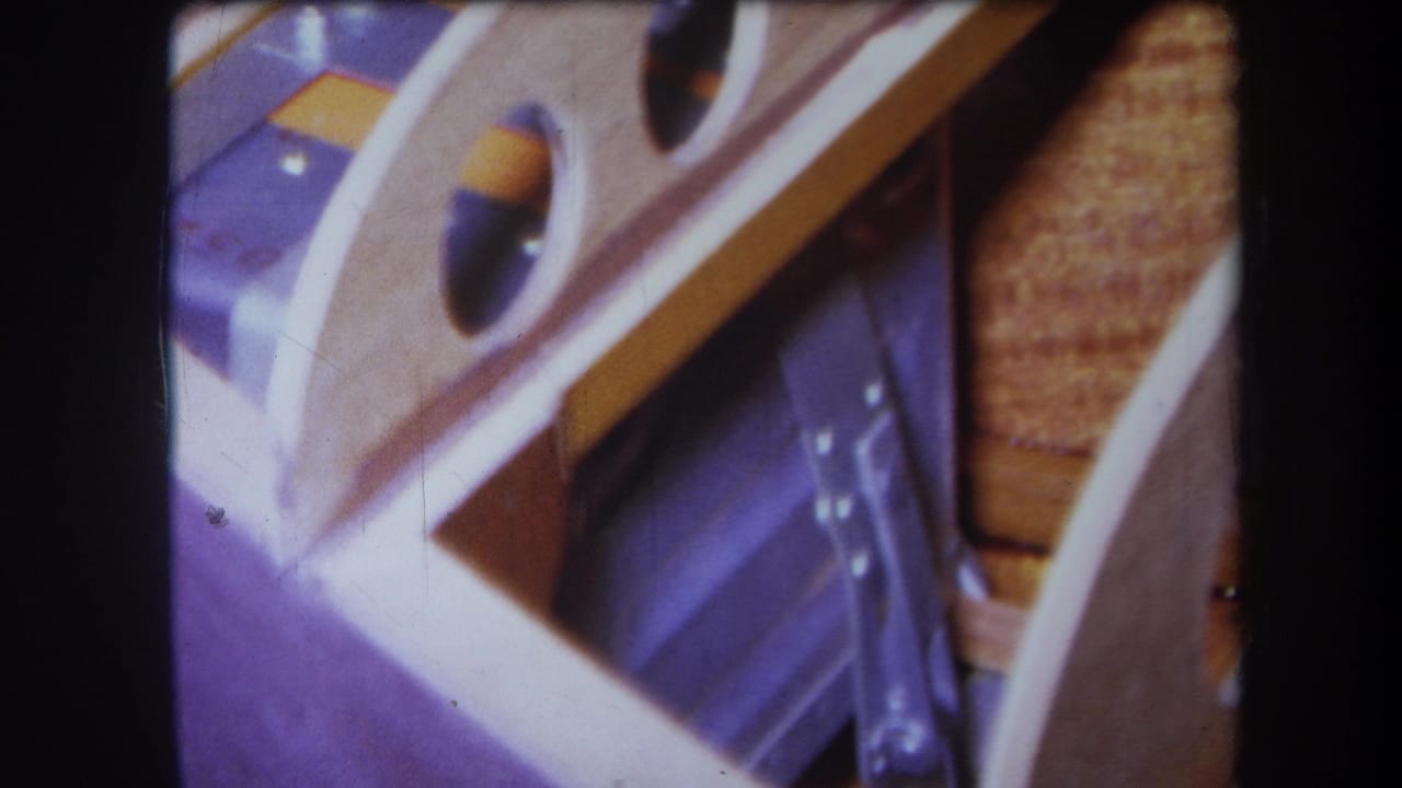 1964 Yucaipa 8mm frame showing the same close wooden form, round openings, purple area, and dark edge borders.