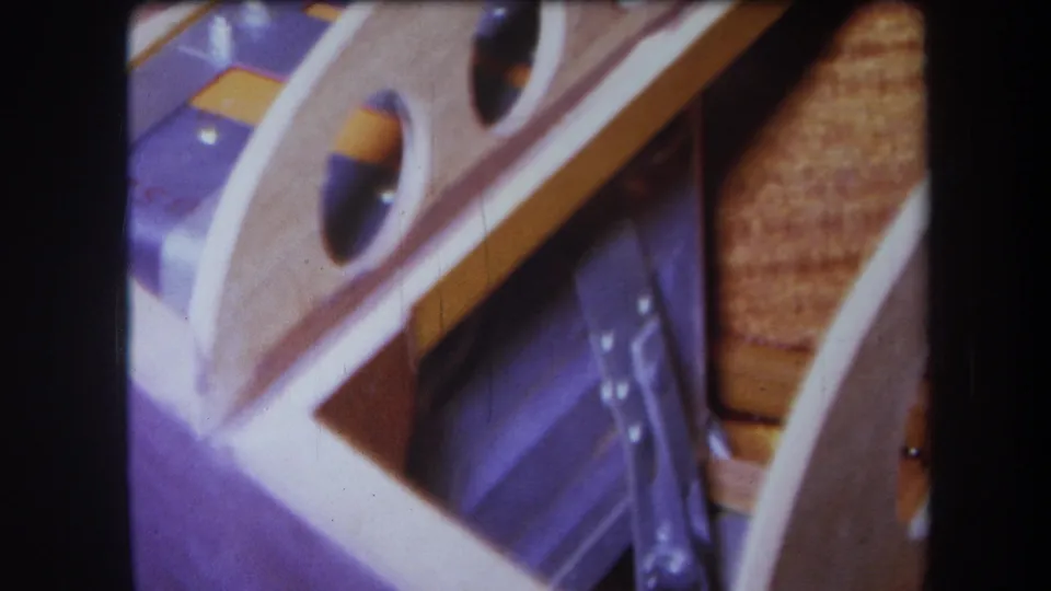 1964 Yucaipa home-movie close-up of pale wood, circular openings, purple surfaces, and visible film grain.