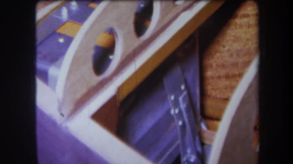 Final 1964 Yucaipa 8mm frame of the close wooden object, purple area, yellow strip, and tan textured section.