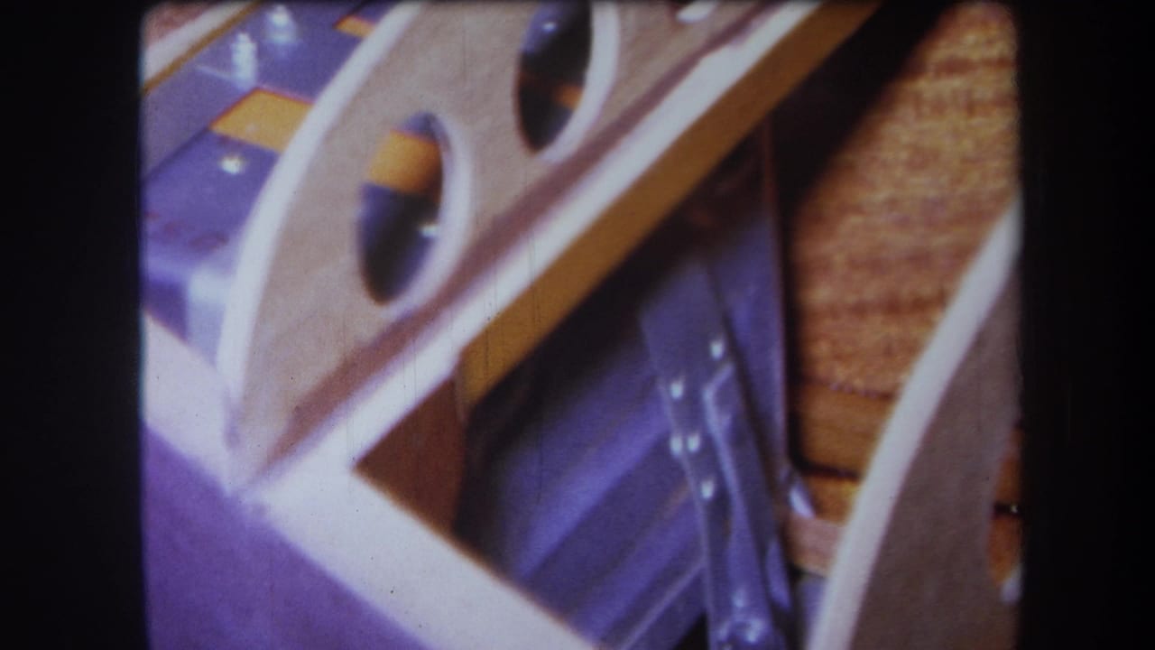 1964 Yucaipa 8mm close-up of wood planks, purple-painted metal surfaces, circular openings, and silver fixture details.