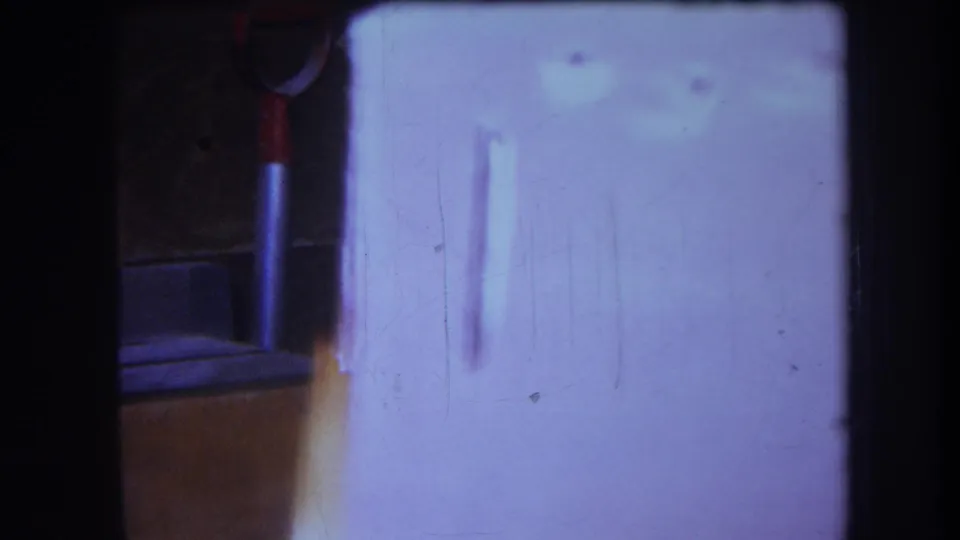 1964 Yucaipa-area 8mm frame showing a white cupboard door with small circular holes and a dark surrounding interior edge.