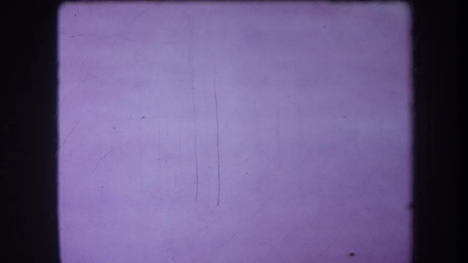 Blank purple 8mm frame from the supplied 1964 Yucaipa reel, showing soft grain, dust, and vertical scratch marks.