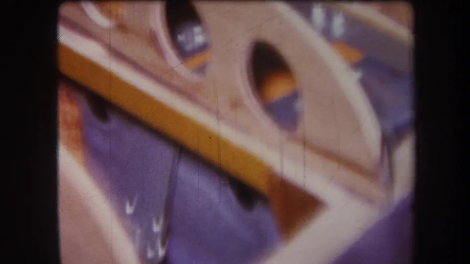 1964 Yucaipa home-movie close-up of a tan wooden frame laid diagonally across a blue surface.