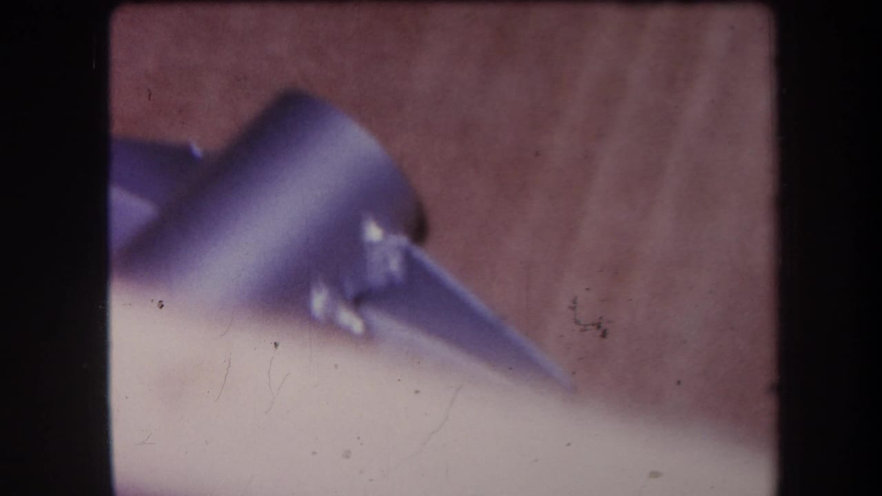 Purple-blue metal fixture resting on a wooden surface in soft focus.