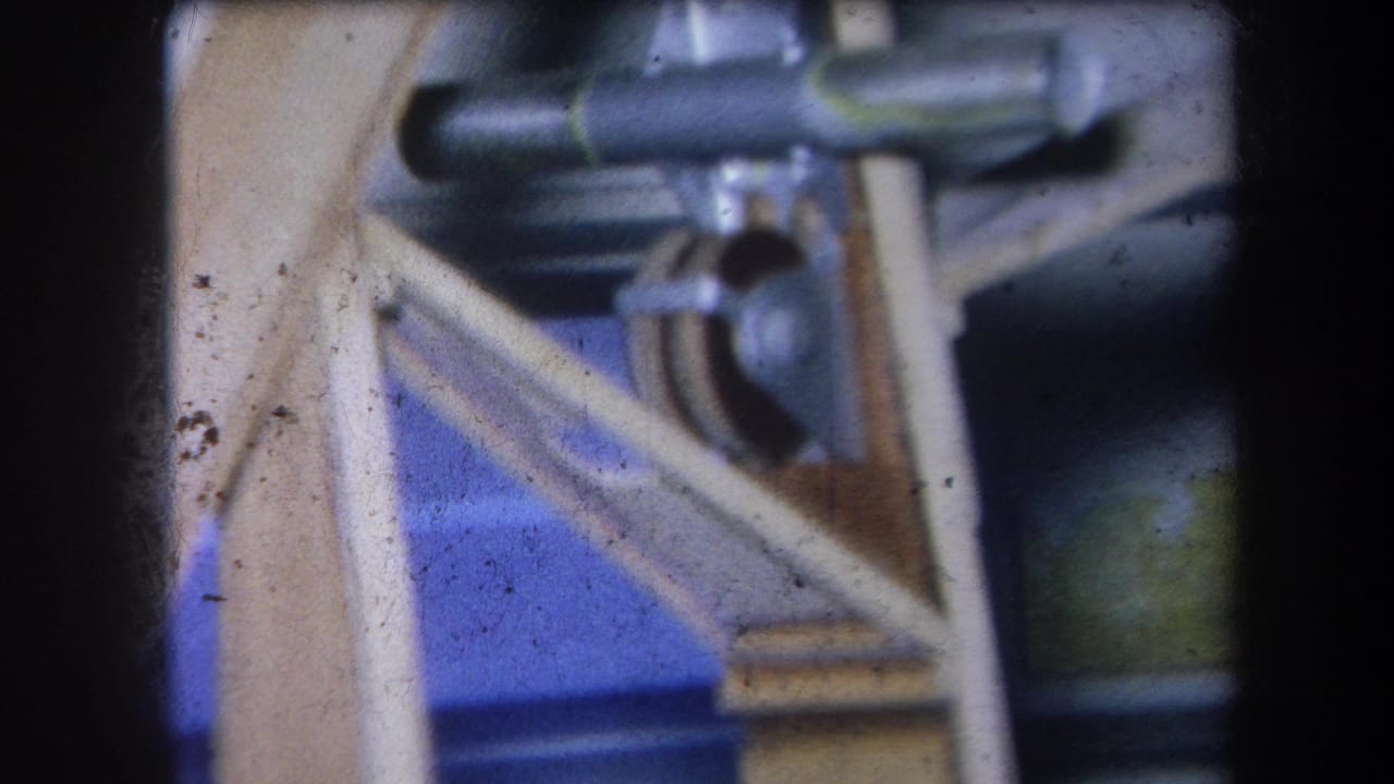 Metal mechanical parts and wooden supports seen in a soft 8mm close-up.