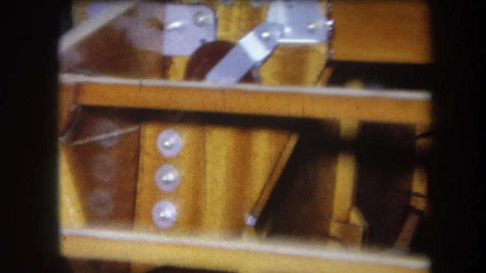 1964 Volmer Yucaipa close-up of varnished wooden machinery with silver brackets, round bolts, and a horizontal bar.