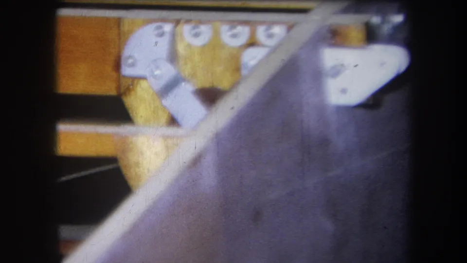 Final 1964 frame from Yucaipa showing a wooden boat frame with exterior planking, silver fixtures, and visible 8mm film texture.