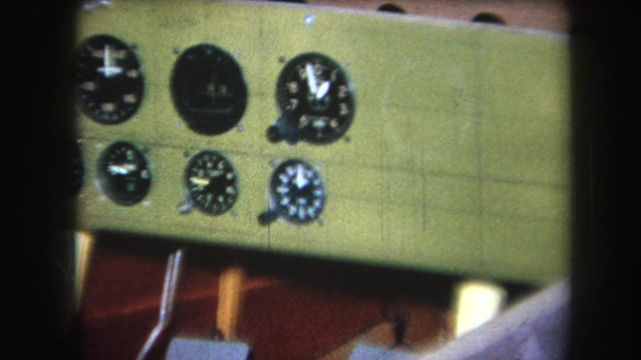 Right side of a green instrument panel with several black analog gauges.
