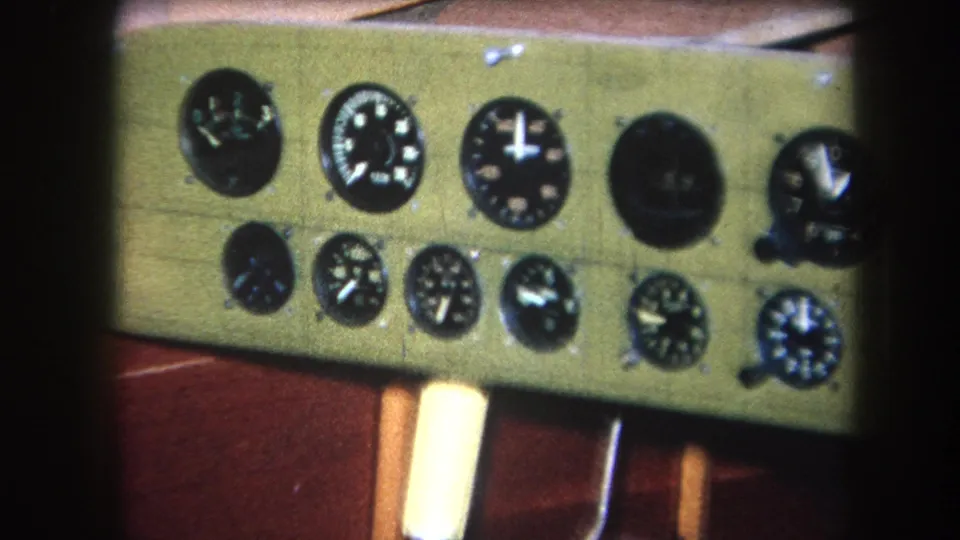 Final 1964 8mm frame holding on the green analog instrument panel with round dials and surrounding wood structure.