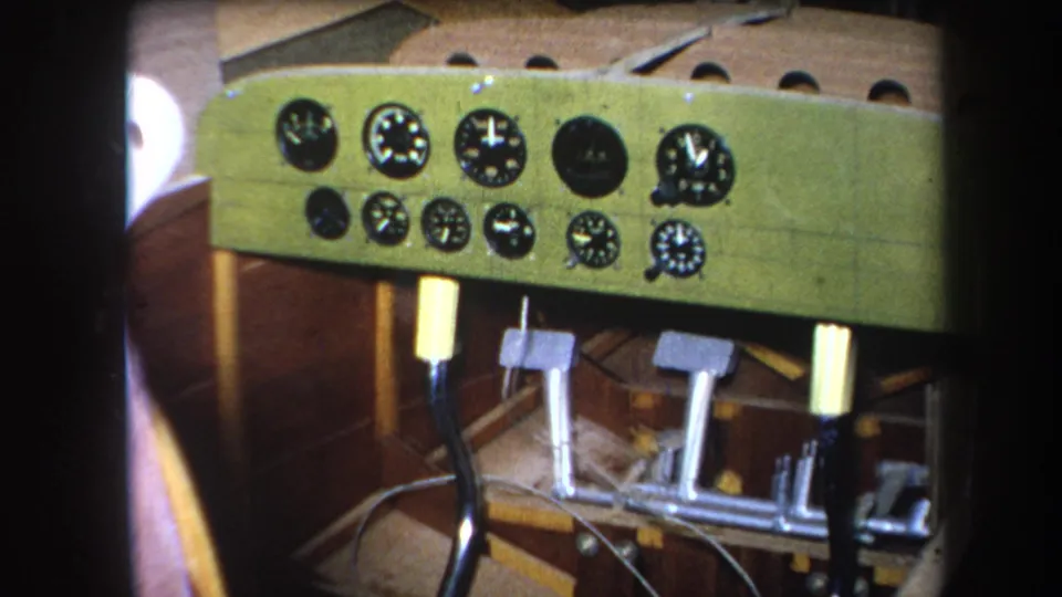 A slightly wider 1964 8mm view shows the homemade aircraft cockpit panel, several round instruments, pedal assembly, and surrounding woodwork.