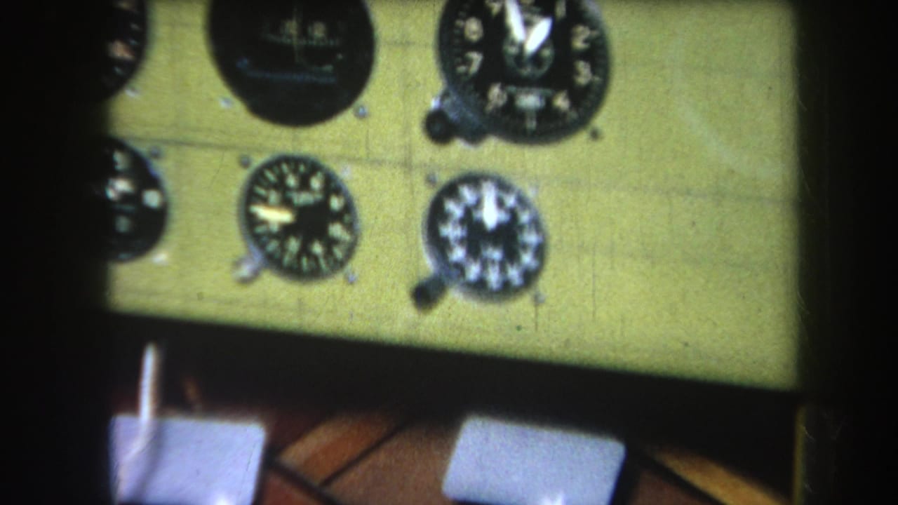 1964 8mm frame from Yucaipa-area footage showing a soft close-up of analog cockpit gauges on a pale instrument panel.