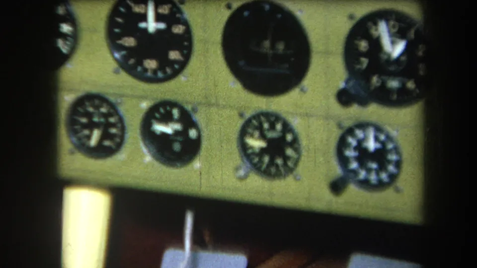 1964 home-movie frame showing a cockpit instrument cluster divided by dark framing, with several analog dials visible.