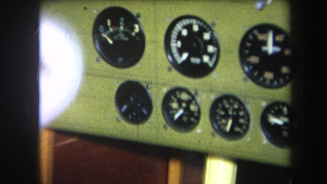 1964 8mm frame from Yucaipa-area footage showing several round analog gauges on a pale green mechanical panel.