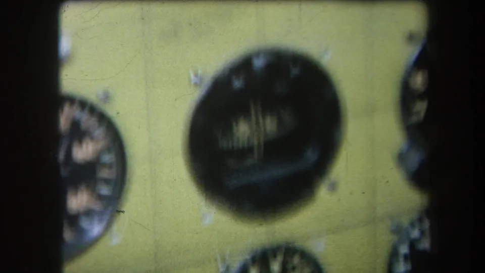 1964 8mm frame from Yucaipa showing a soft-focus yellow instrument panel with round analogue dials and white markings.