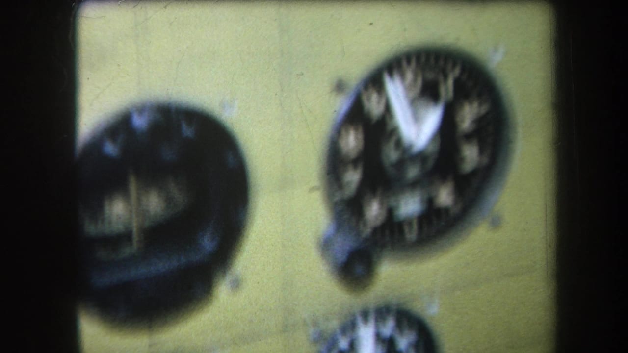 1964 Volmer Yucaipa footage showing a soft-focus yellow airplane cockpit instrument panel with dark round gauges and white needles.